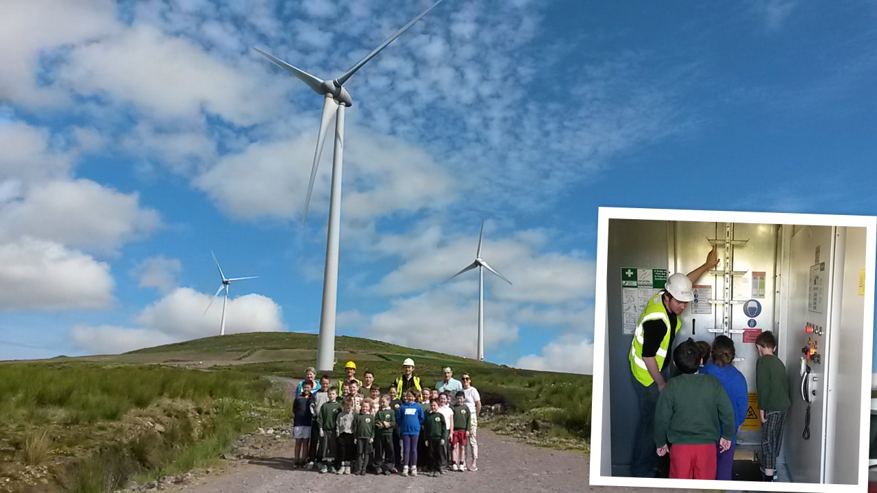 Schoolchildren stand in group under wind turbine