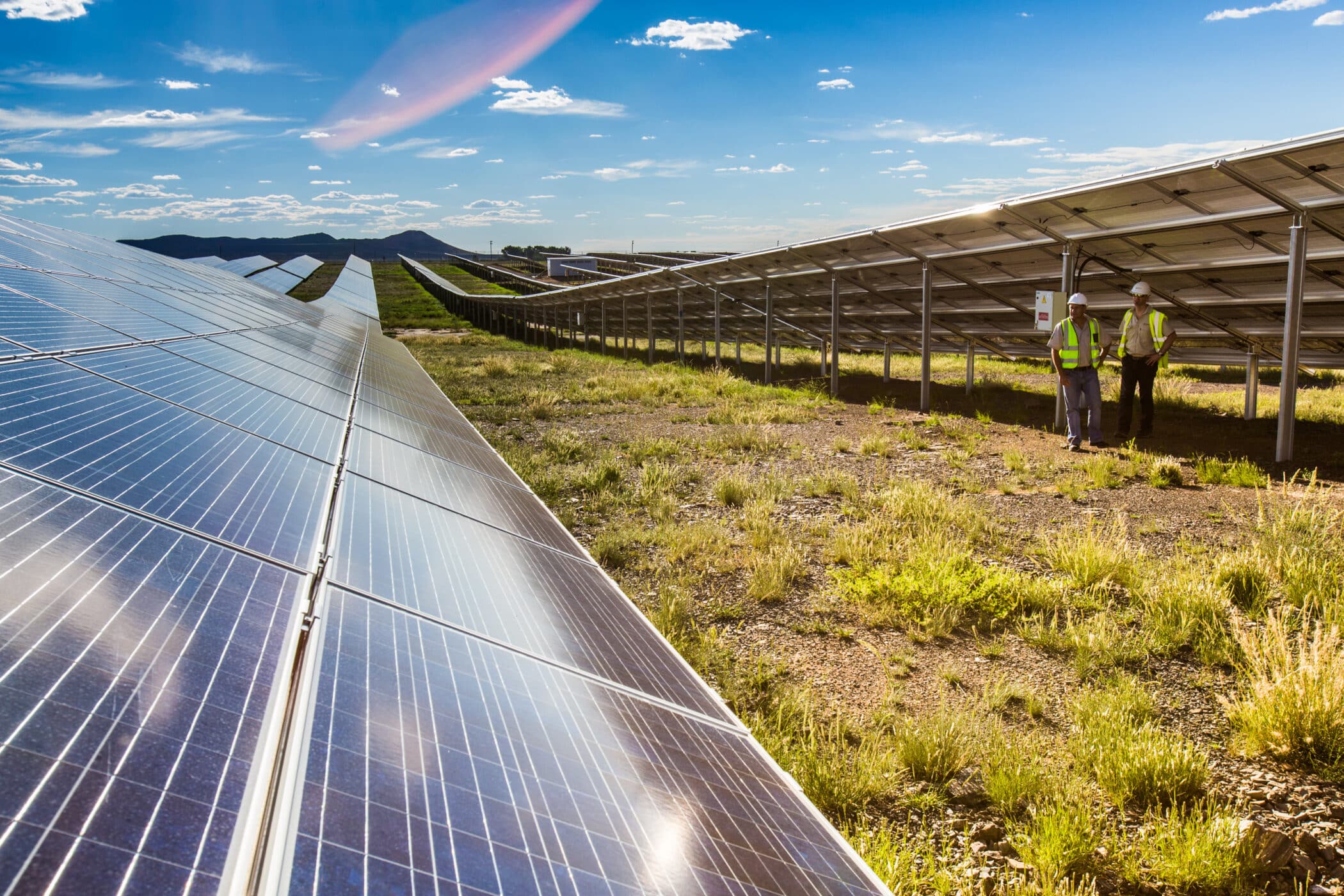 rows of solar PV panels under blue sky