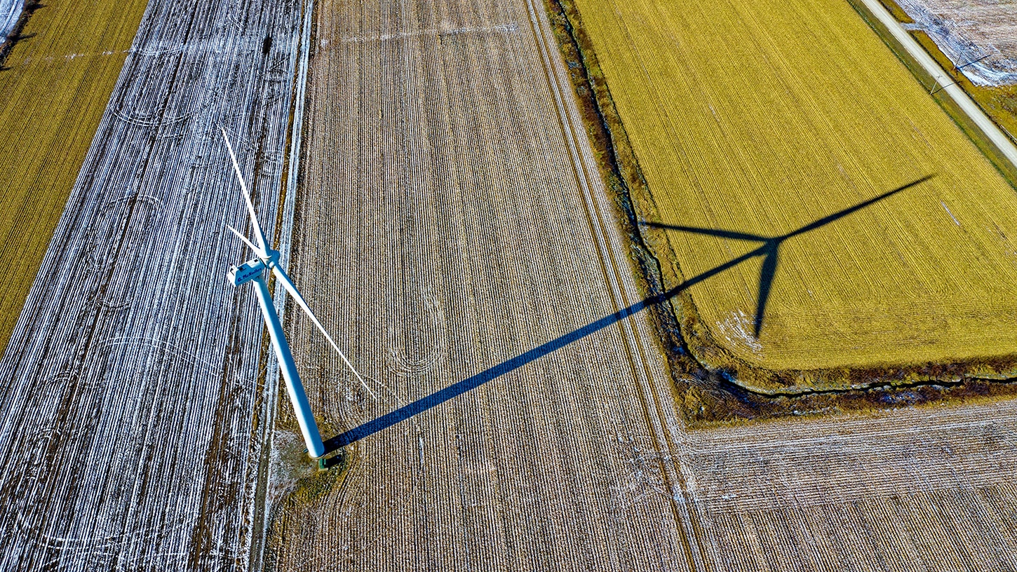 Aerial picture looking down on wind turbine and it shadow