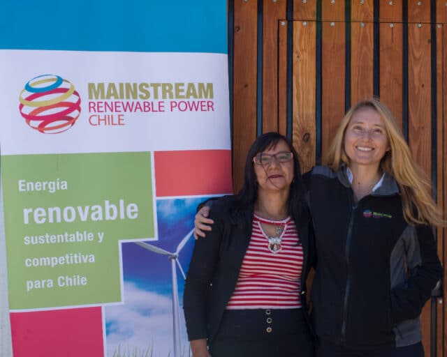 Irene and Ana maria embrace by mainstream renewable power banner