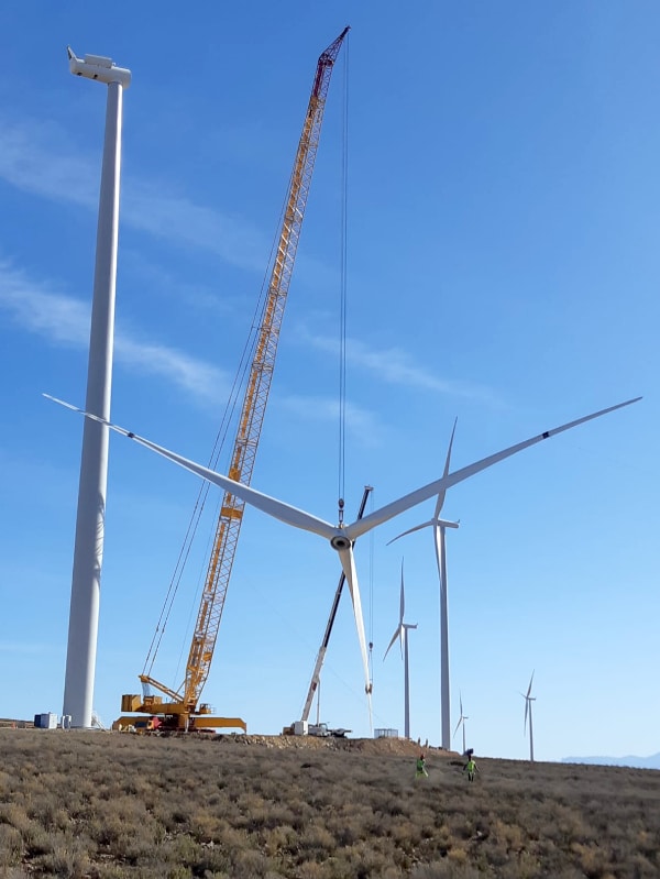 Crane lifting turbine blades up to nacelle