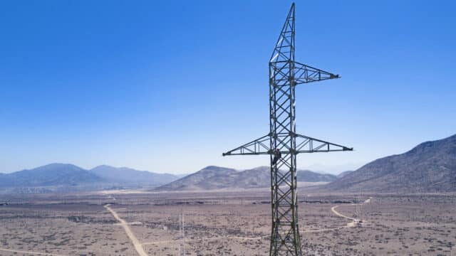 Aerial photo of construction workers installing transmission pylon in Chilean desert