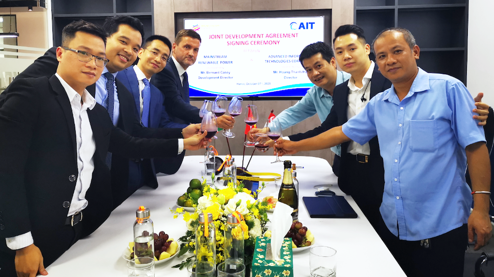 Mainstream's Development Director in Vietnam, Bernard Casey, centre left, and AIT Director Hoang Thanh Hai, centre right, lead their teams in toasting the new joint venture agreement at the signing ceremony in Hanoi