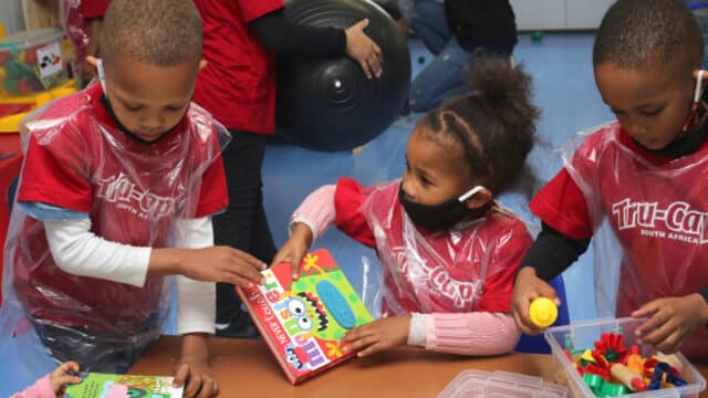 pre-primary children playing at table in new classroom