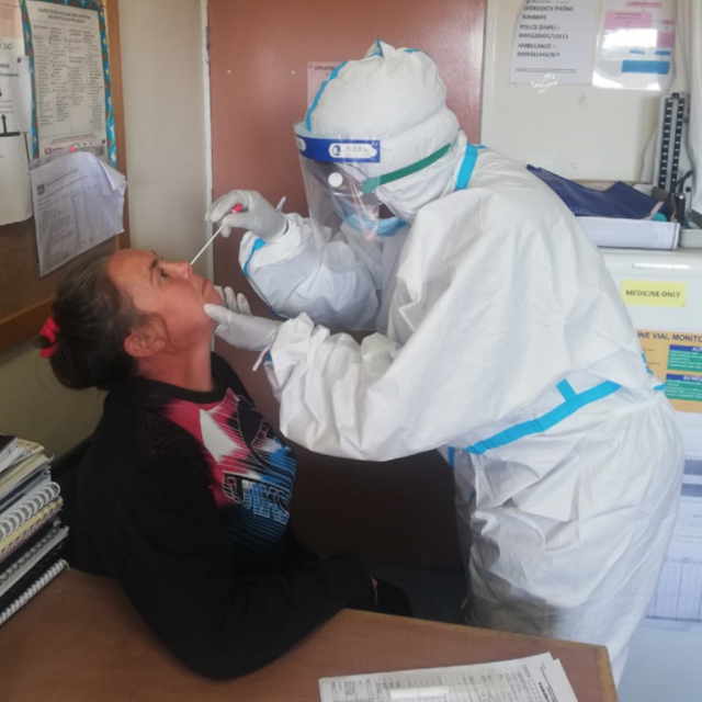 Nurse in PPE treating patient