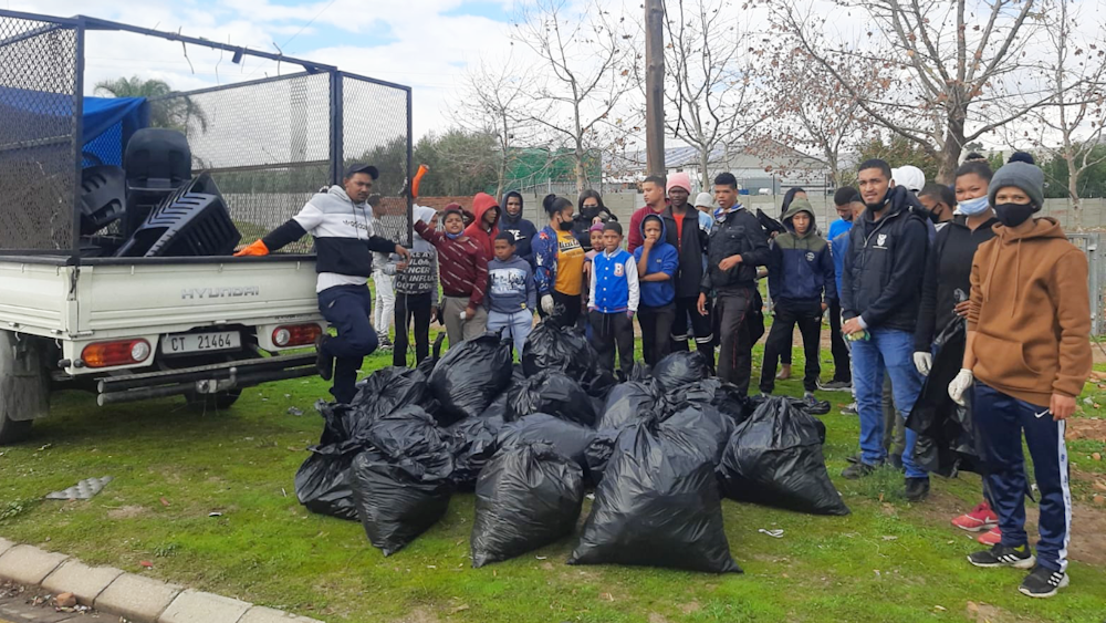 Young volunteers show off bags of rubbish
