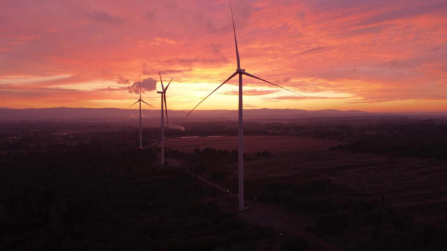 Wind turbines against a sunset