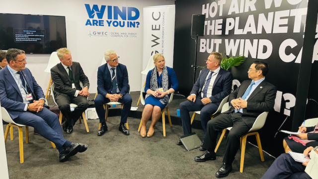 Mainstream Chief Executive Mary Quaney, centre, in discussion with Prime Minister Pham Minh Chinh, right, at GWEC's COP26 pavillion