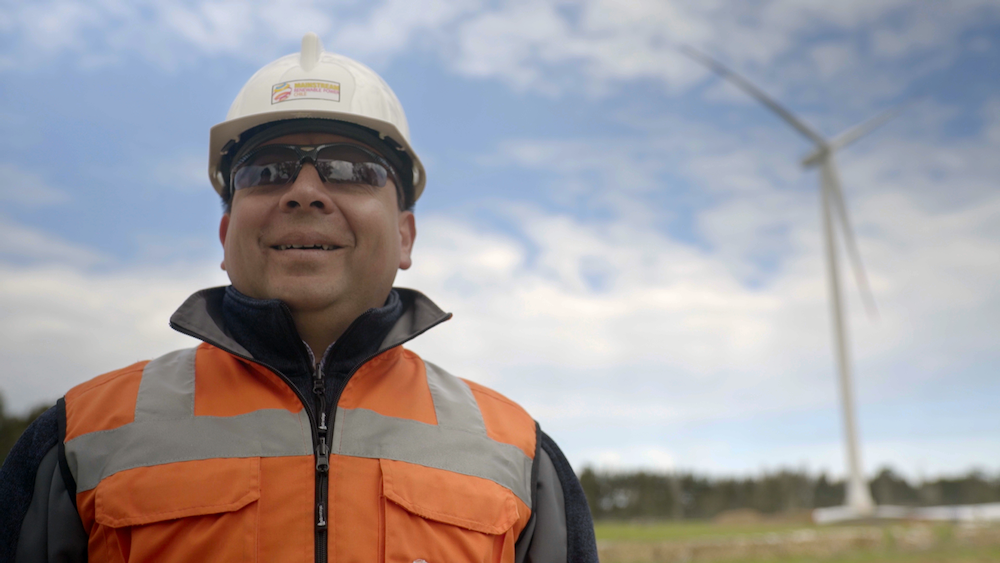 Mainstream worker standing at an onshore wind farm in Chile.