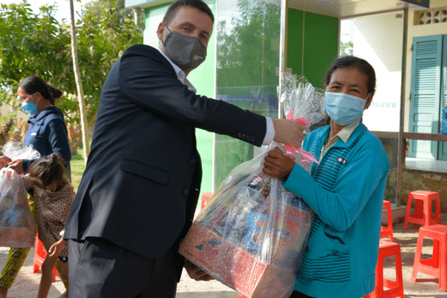 Bernard Casey, Chief Operating Officer APAC, distributes food packages to local woman