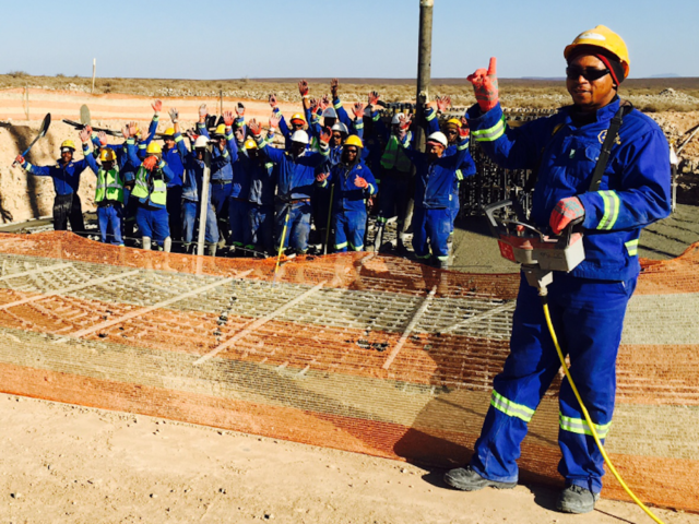 South African workers celebrate laying of wind turbine foundation