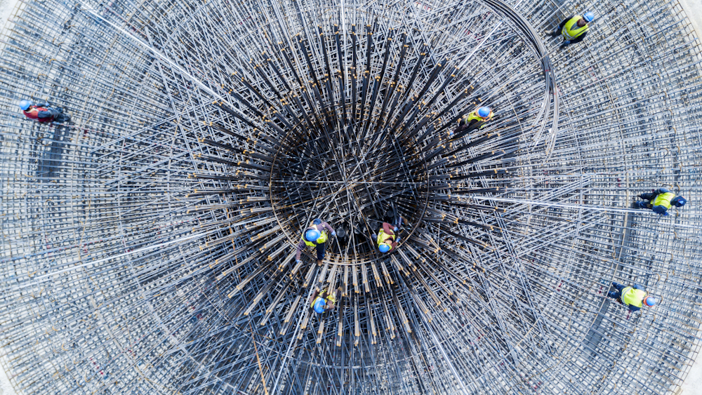 aerial photo of construction team standing ontop of wind turbine foundations before laying concrete