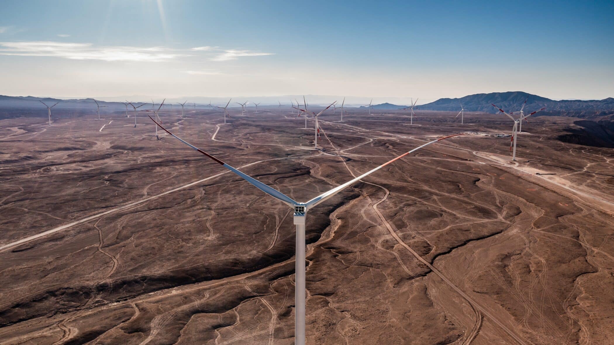 image of an onshore wind farm in Chilean desert with mountains in background