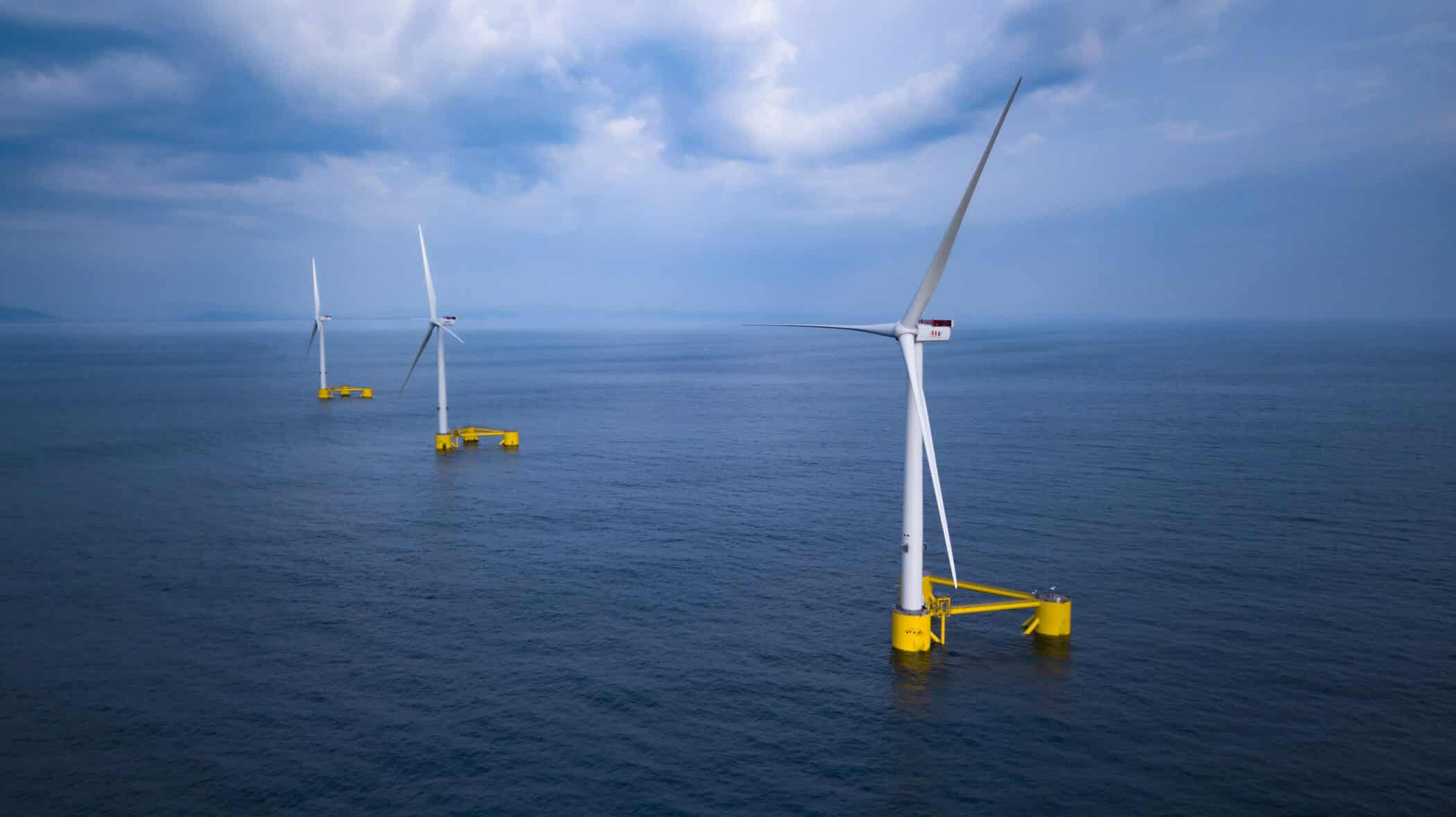 three floating Offshore wind turbines sitting out at sea
