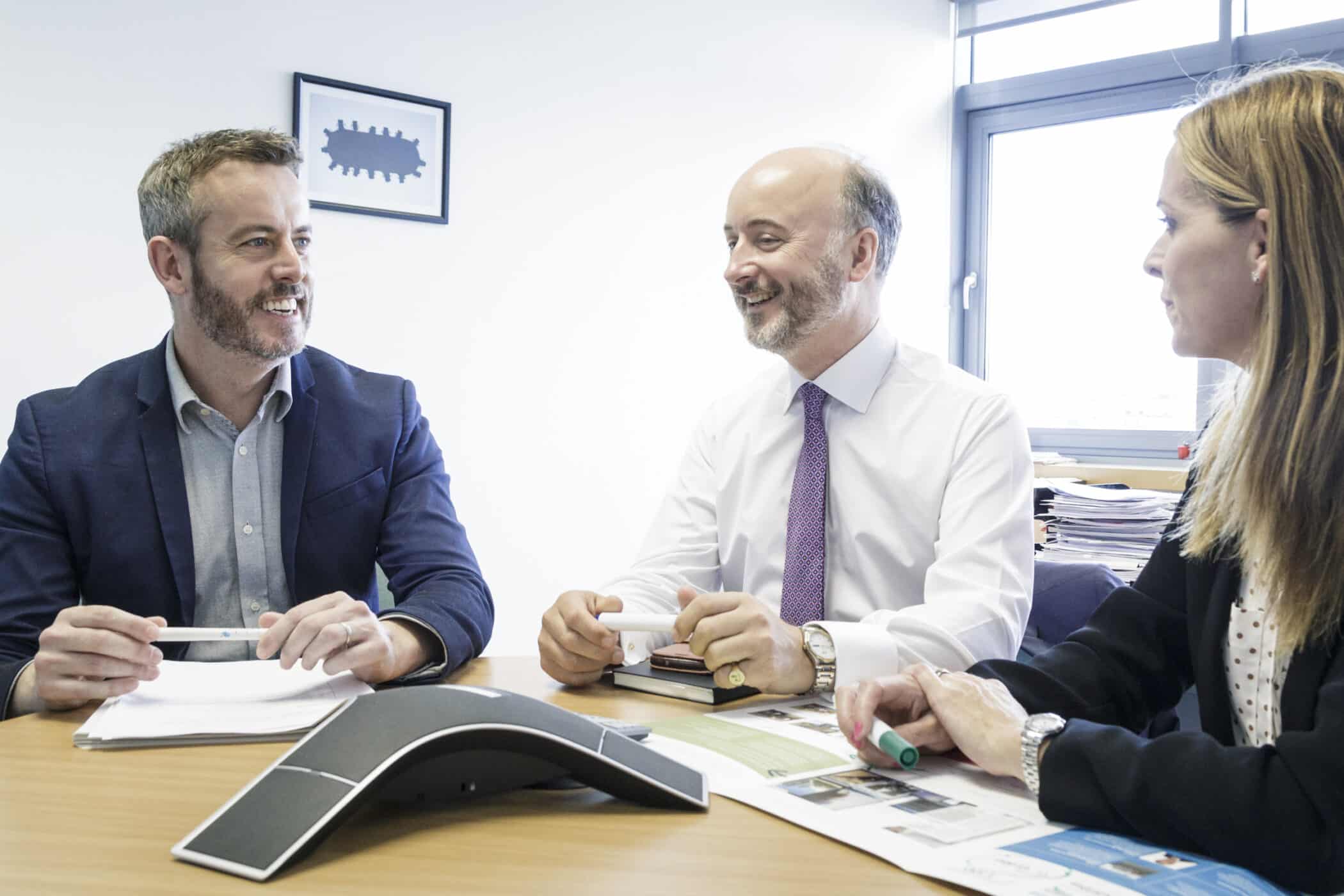 Three team members sitting and talking together in an office - vision mission values Mainstream Renewable Power