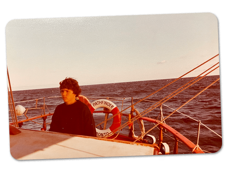boy at helm of sailing boat